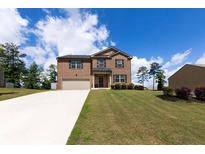Inviting two-story brick home with a well-manicured lawn and attached two-car garage at 446 Noblewood Dr, Mcdonough, GA 30252