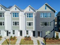 Charming new construction townhomes with painted brick and landscaped yards under clear, sunny skies at 103 Mission Se Way # 103, Atlanta, GA 30315