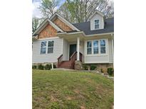 Charming home with a unique shake shingle accent, complemented by a landscaped front yard and stone foundation detail at 4075 Sw Fairburn Sw Ave, Atlanta, GA 30331
