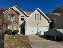 Charming two-story home boasts a two-car garage and a mix of brick and siding accents at 11631 Kades Trl, Hampton, GA 30228