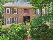 Charming two-story brick home with black shutters and lush landscaping at 2030 Spring End Ct, Lawrenceville, GA 30044