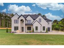 Striking two-story white brick home featuring a large, well-manicured front lawn and black trim details at 3205 Bold Springs Rd, Dacula, GA 30019