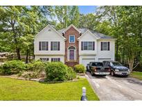 Charming two-story home with a well-manicured lawn and inviting curb appeal surrounded by mature trees at 5181 Saint Claire Pl, Powder Springs, GA 30127
