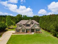 Two story home on a well manicured lawn, with a basketball hoop, large driveway and mature trees at 127 Grayson Myers Dr, Villa Rica, GA 30180