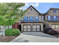 Brick two-story home with attached two-car garage and well-manicured landscaping at 5870 Shiloh Woods Dr, Cumming, GA 30040
