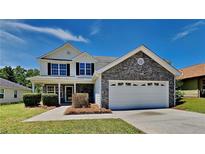 Charming two-story home featuring a stone facade, attached garage, and a well-maintained front yard at 10961 Big Sky Dr, Hampton, GA 30228