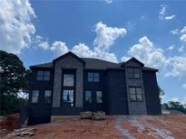 Striking two-story home with large windows and stone accents, set against a bright blue sky at 3066 Reserve Sw Ct, Conyers, GA 30094