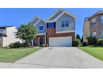 Two-story home with brick and siding, attached two-car garage, and well-maintained lawn in a residential area at 3168 Sag Harbor Ct, Buford, GA 30519