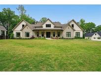 Beautiful home featuring a well-manicured lawn, stone accents, and a covered porch perfect for relaxing at 131 Forsyth Park Ln, Woodstock, GA 30188