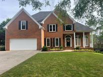Charming brick home with a manicured lawn, two-car garage, and inviting front porch at 315 Hembree Grove Trce, Roswell, GA 30076