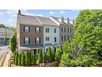 Beautiful townhome with brick and siding, a manicured front yard and a two car garage at 1914 Forte Ln, Alpharetta, GA 30009