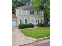 Charming two-story home with a well-manicured lawn and classic architectural details at 215 Boca Ciega Ct, Alpharetta, GA 30022
