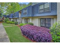 Attractive exterior of this townhome featuring a well-manicured lawn and lush landscaping at 157 Maribeau Nw Sq, Atlanta, GA 30327
