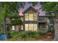 Charming two-story home with multiple windows and balconies surrounded by mature trees and lush landscaping at 2105 Country Park Se Dr, Smyrna, GA 30080