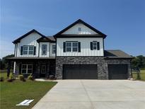 Charming two-story home with stone accents, a three-car garage, and a well-manicured lawn at 2749 Porches Ln, Dacula, GA 30019
