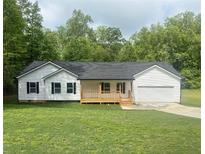 Charming single-story home with white siding, black shutters, a front porch, attached garage, and a well-maintained lawn at 201 Deerfield Ln, Carrollton, GA 30116