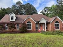 Charming brick home with manicured lawn and mature trees, offering great curb appeal at 300 Gaelic Way, Tyrone, GA 30290
