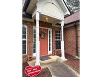 Welcoming brick home featuring a covered entryway and lovely front door wreath at 300 Gaelic Way, Tyrone, GA 30290