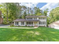 Inviting two-story white brick home featuring black shutters and a meticulously maintained front lawn at 4367 Cedar Wood Sw Dr, Lilburn, GA 30047