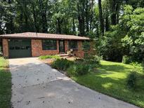 Charming brick home with a well-maintained lawn and attached garage at 1094 Seville Dr, Clarkston, GA 30021
