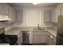 The kitchen features stainless steel appliances and gray cabinets at 1105 Natchez Trce, Atlanta, GA 30350