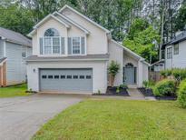 Charming two-story home featuring a gray garage door, a well-manicured lawn, and fresh landscaping at 1265 Watercrest Cir, Lawrenceville, GA 30043