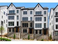 Attractive townhome featuring a white facade, black trim, and stone accents, creating a modern and inviting exterior at 2052 Lanier Grv, Alpharetta, GA 30009
