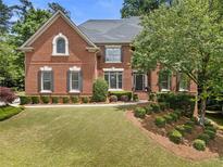 Charming two-story brick home with a well-manicured lawn and lush landscaping at 330 Broad Leaf Ct, Johns Creek, GA 30022