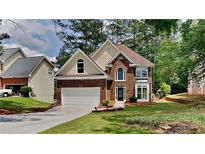 Charming two-story brick home with landscaped front yard and attached two car garage at 6845 Gledhill Way, Stone Mountain, GA 30087