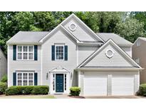 Charming two-story home with gray siding, dark shutters, and a two-car garage, framed by mature trees at 2821 Amhurst Nw Way, Kennesaw, GA 30144