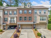 Charming brick townhouse featuring a two-car garage and a well-maintained facade at 286 Blue Pointe Ct, Suwanee, GA 30024