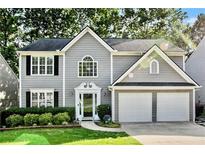Charming two-story home with gray siding, black shutters, two-car garage and beautifully manicured lawn at 4311 Sentinel Nw Pl, Kennesaw, GA 30144