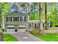 Charming two-story home with a two-car garage and inviting front porch nestled among mature trees at 4330 Volnay Ne Ct, Marietta, GA 30066