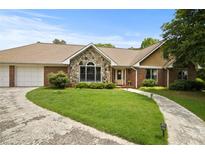 Charming single-story home with stone accents, a well-manicured lawn, and a paved driveway leading to an attached garage at 2139 Bramlett Nw Pl, Marietta, GA 30064