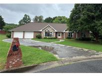 Charming single-story brick home featuring a stone accent, two-car garage, and well-manicured front yard at 2139 Bramlett Nw Pl, Marietta, GA 30064