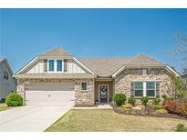 Charming single Gathering home featuring stone accents, a two-car garage, and a well-manicured lawn at 3715 Bridges Ct, Cumming, GA 30040