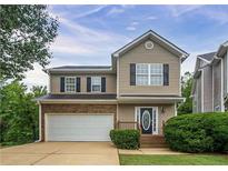 Charming two-story home featuring a front-facing garage, a covered entryway, and manicured landscaping at 107 Providence Run, Dallas, GA 30157