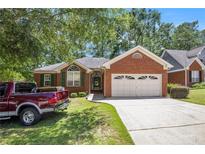 Charming brick home with a two-car garage and a well-maintained front yard and a red pickup truck at 6718 Oakhurst Ct, Douglasville, GA 30134