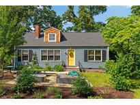Charming home featuring a landscaped front yard with garden beds and a bright yellow front door at 131 Lively St, Norcross, GA 30071