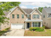 Charming two-story brick home featuring a two-car garage, well-manicured lawn, and inviting front porch at 1310 Scenic View Trce, Lawrenceville, GA 30044