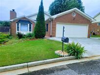 Charming brick home featuring a manicured front lawn, brick exterior, and attached two-car garage at 4503 Hunters Ter, Stone Mountain, GA 30083