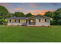 Charming brick home featuring a well-maintained lawn and inviting front porch at 3600 Anglin Rd, Loganville, GA 30052