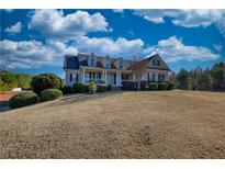 Charming two-story home featuring a welcoming front porch and well-manicured landscaping, perfect for serene suburban living at 4180 Mount Paran Dr, Social Circle, GA 30025