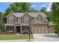 Beautiful two-story brick home with lush landscaping, a welcoming front porch, and three-car garage at 1136 Garner Creek At Parkview Sw Dr, Lilburn, GA 30047
