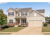 Charming two-story home featuring a manicured lawn, neutral siding, and attached two-car garage at 704 Woodbridge Dr, Woodstock, GA 30188