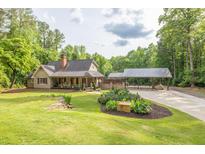Charming single-Gathering home with large manicured front lawn and a covered parking area at 814 Clarke Trl, Dacula, GA 30019