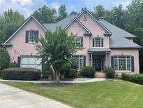 Charming pink brick home featuring lush landscaping, symmetrical design, and a welcoming front entrance at 1029 Laurel Grove Cts, Suwanee, GA 30024