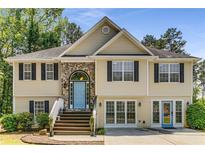 Charming two-story home featuring a stone archway and a light blue front door at 3835 Annandale Ln, Suwanee, GA 30024