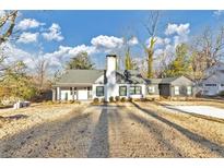 Charming home boasts a well-manicured front lawn, white paint, black trim, and a chimney at 1571 Boulevard Lorraine Sw, Atlanta, GA 30311