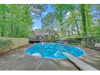 Inviting backyard pool area featuring an in-ground pool, diving board, and surrounding lush greenery at 2505 Oakrill Rd, Marietta, GA 30062